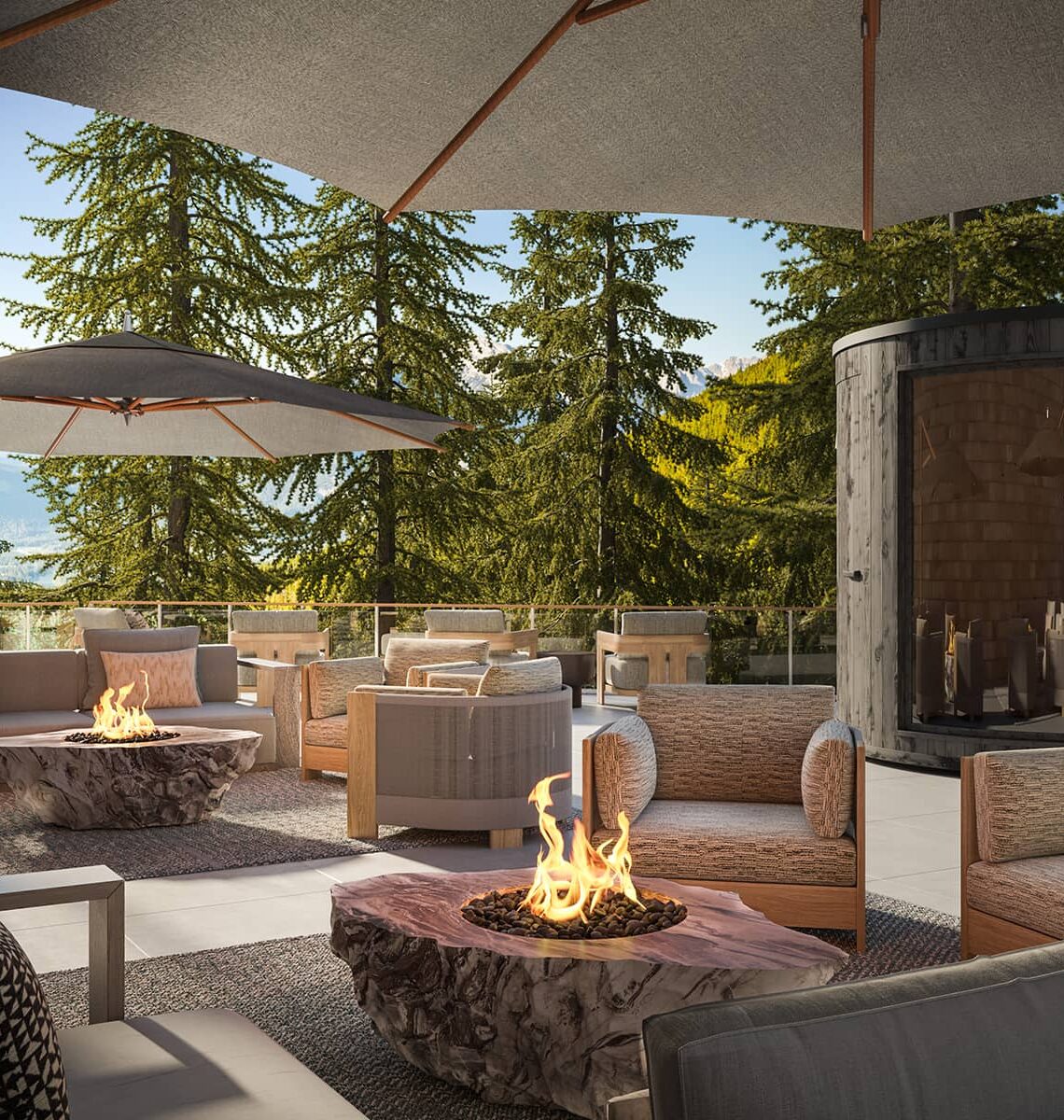 Outdoor terrace at Rimrock Banff, Emblems Collection with barrel saunas, firetables, and lounge seating surrounded by forest and mountain views.