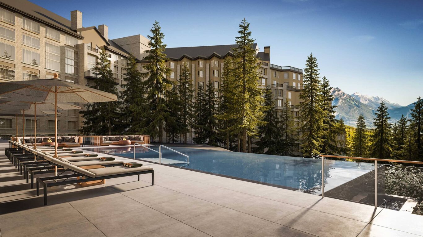 The wellness reception at Rimrock Banff, Emblems Collection features a curved wooden staircase, a juice bar with bottled drinks, seating area, and sculpted climbing wall.