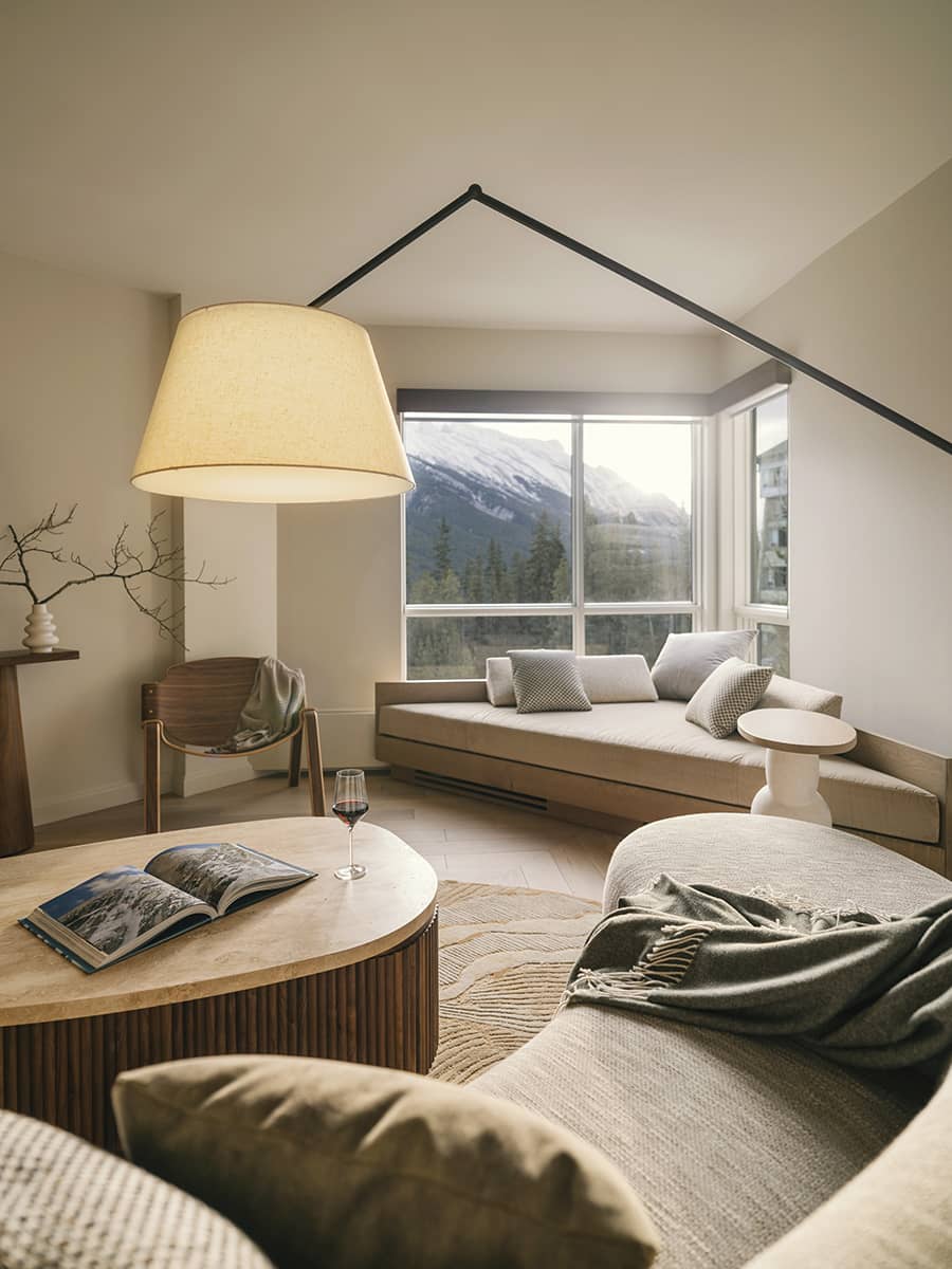 A serene Rimrock Banff guest room with a plush bed, warm lighting, and natural tones that create an inviting sense of calm and refined mountain comfort.