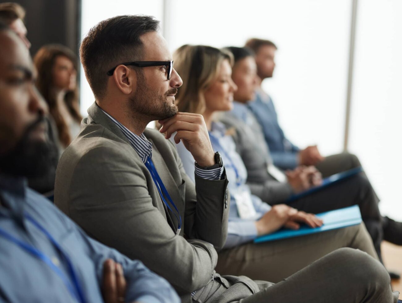 Guests engaged in a focused presentation inside the Alpenglow meeting space at Rimrock Banff.