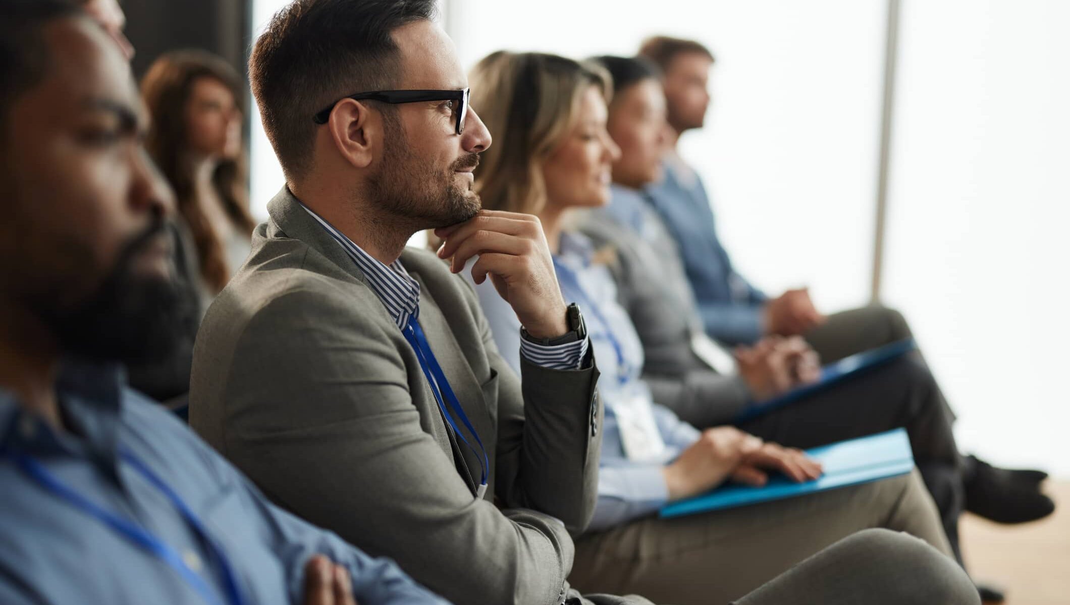 Guests engaged in a focused presentation inside the Alpenglow meeting space at Rimrock Banff.