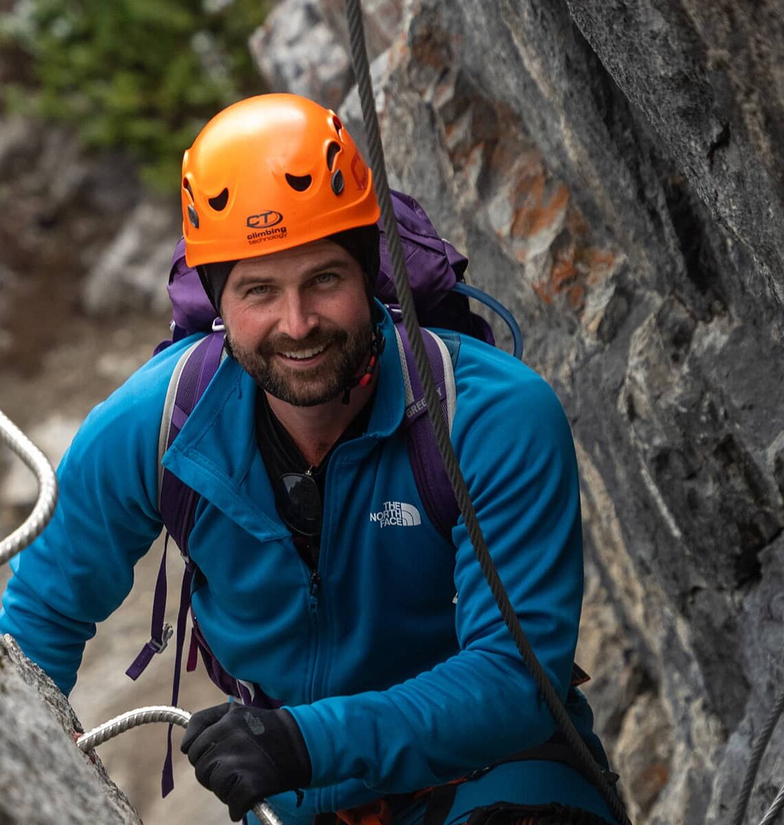 Harnessed climber pauses along Mount Norquay’s Via Ferrata, steady on iron rungs with rock walls rising around him.