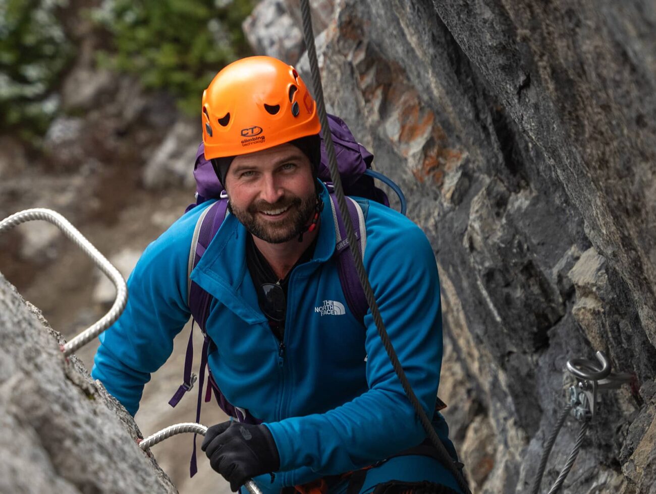 Harnessed climber pauses along Mount Norquay’s Via Ferrata, steady on iron rungs with rock walls rising around him.