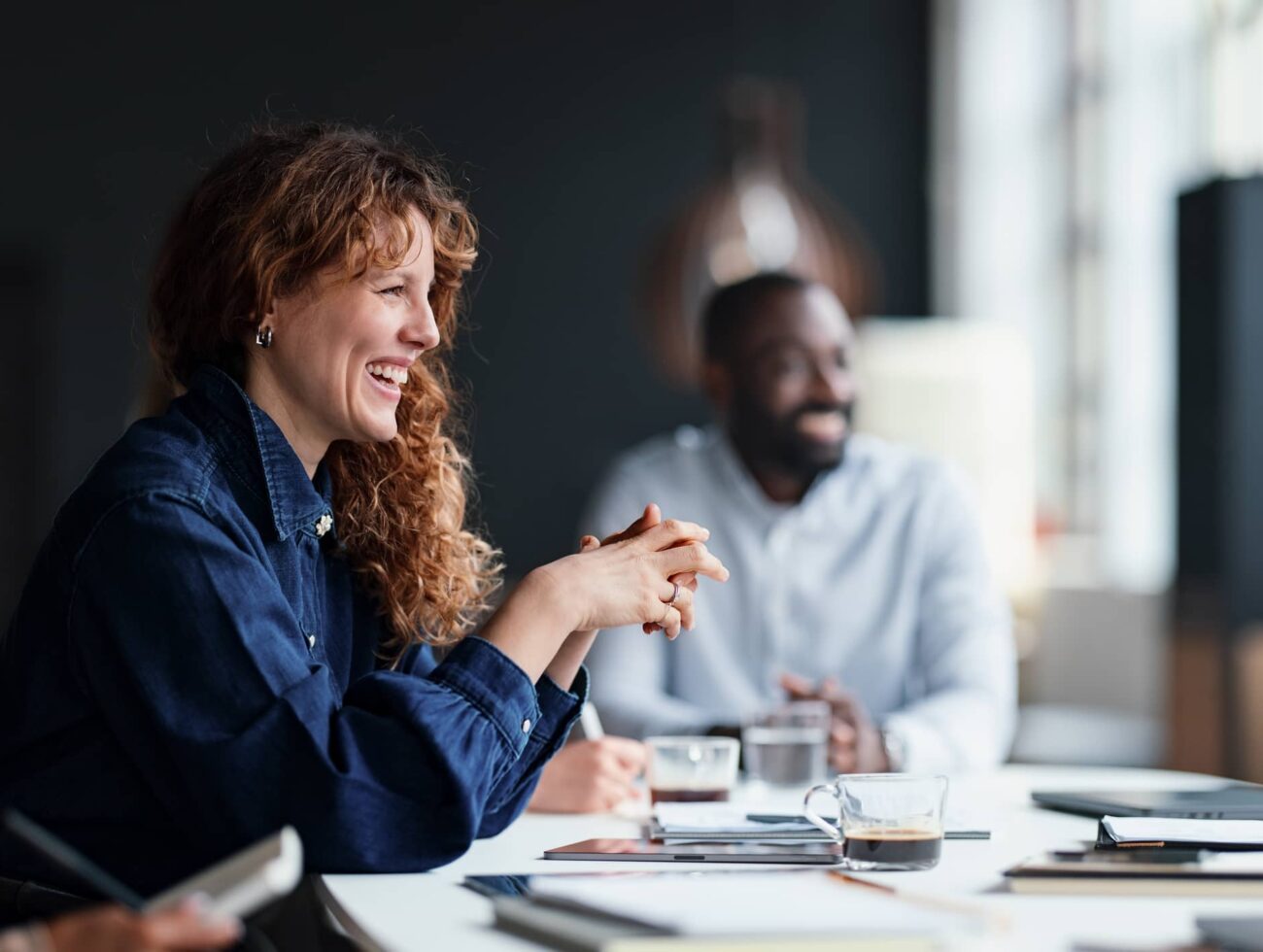 Team discussion taking place in the Dawn meeting room with natural light and views.