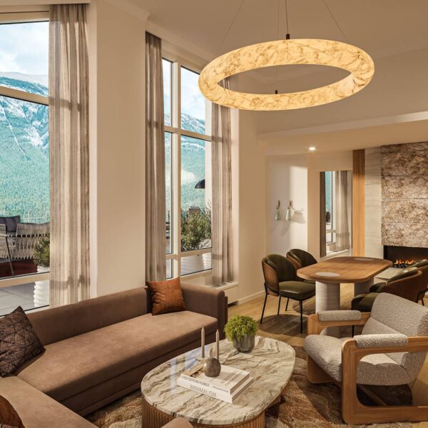 en::A rendering of the Infinity Two-Bedroom Suite at Rimrock Banff featuring a spacious living area with modern furnishings, a fireplace, and floor-to-ceiling windows opening to a terrace with panoramic mountain views. | fr:: Rendu de la suite Infinity à deux chambres du Rimrock Banff avec son salon spacieux, son mobilier moderne, sa cheminée et ses baies vitrées donnant sur la terrasse avec vue panoramique sur la montagne. | es:: Imagen de la suite con dos habitaciones Infinity de Rimrock Banff, que cuenta con una amplia sala de estar con muebles modernos, chimenea y ventanales que se abren a una terraza con vista panorámica a las montañas. |
