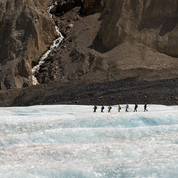 Expansive view across the Athabasca Glacier, highlighting textured ice fields framed by steep rock walls in the Canadian Rockies.