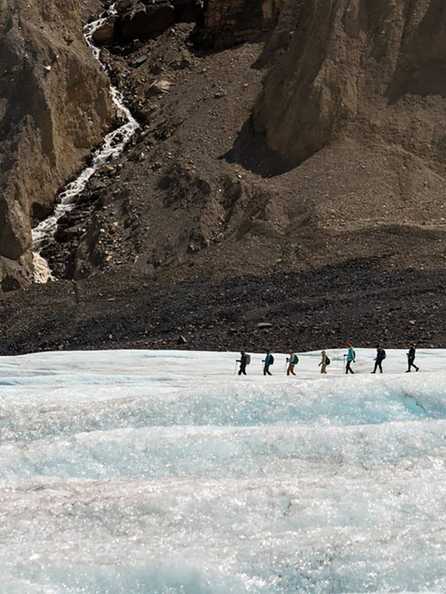 Expansive view across the Athabasca Glacier, highlighting textured ice fields framed by steep rock walls in the Canadian Rockies.