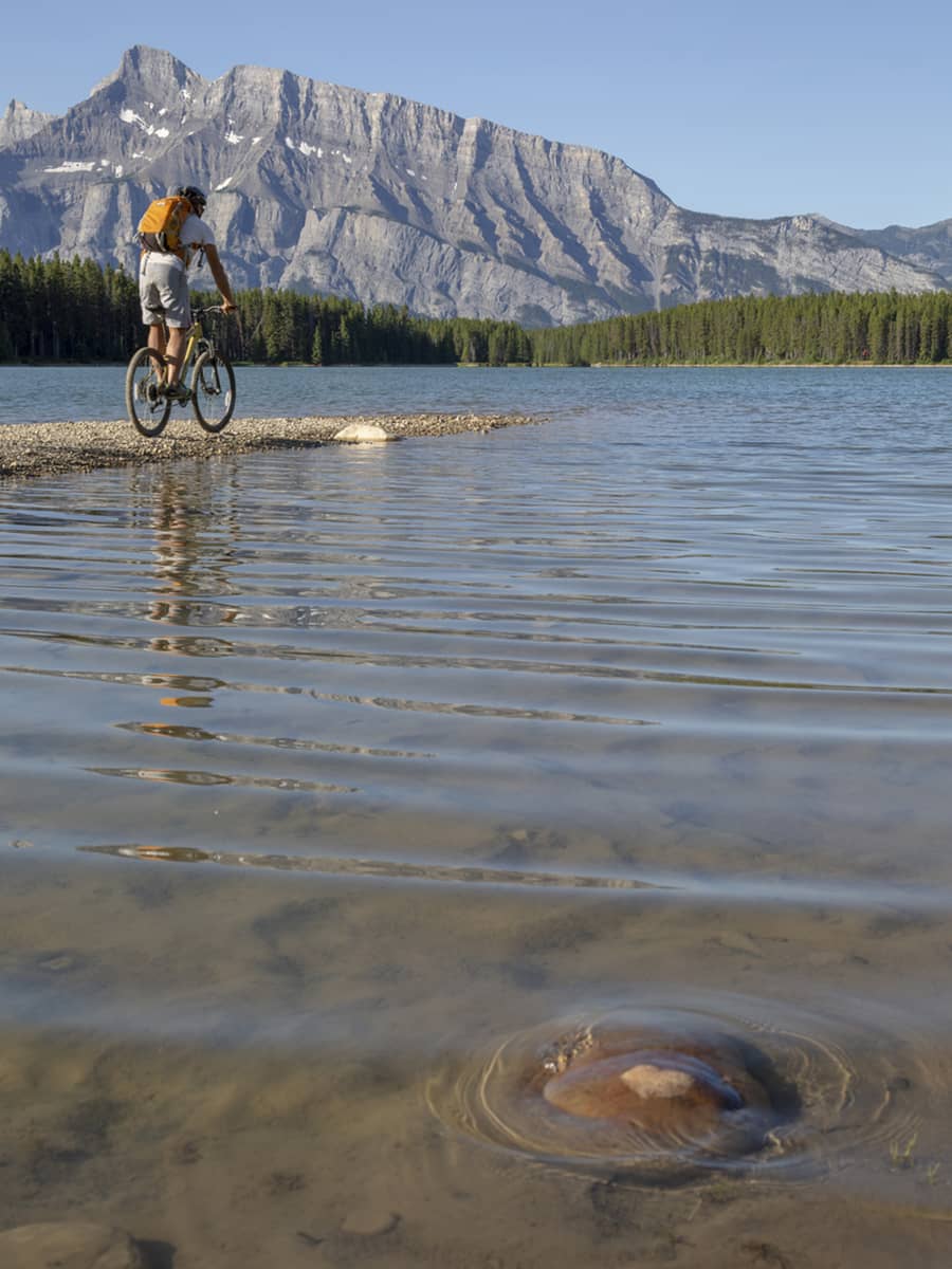 A biker at Cascade Ponds with Rundle in the background