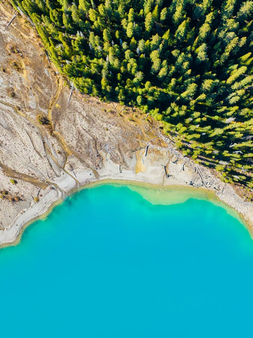 Drone view of the lake and forest in the glacier valley. View of the moraines. Landscape from the air. River on a moraine. Landscape from drone. Abstract view for wallpaper. Banff Alberta, Canada.