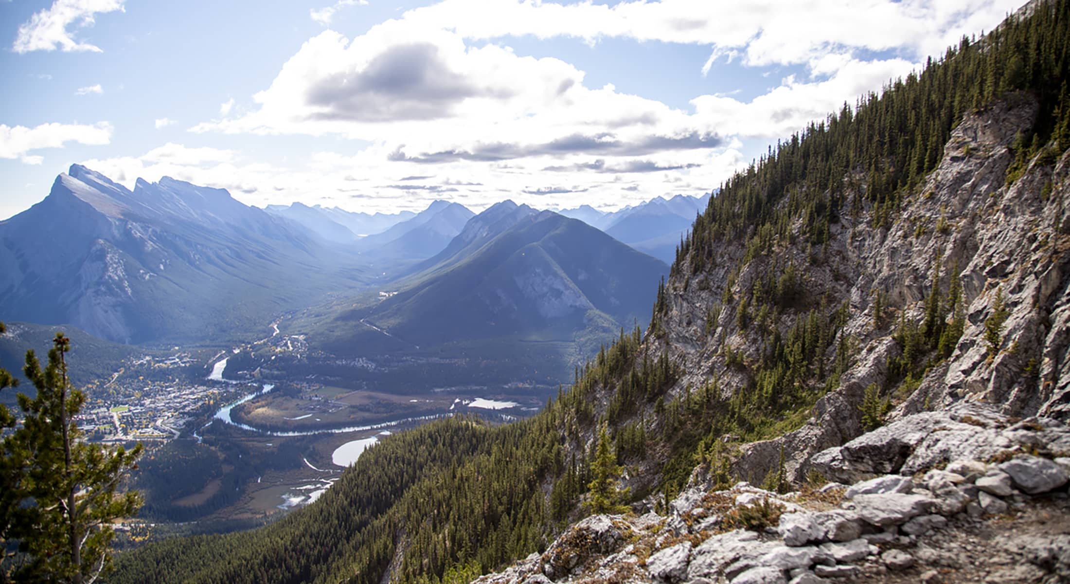 Enjoy luxury travel and panoramic view from Mount Norquay’s Via Ferrata, overlooking the Bow Valley and surrounding peaks under open sky.