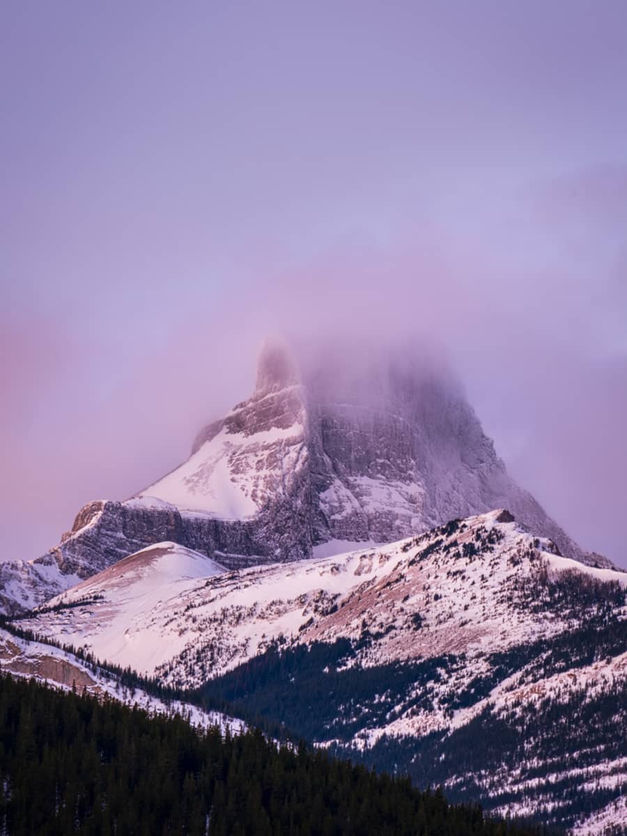 Fortress Mountain in winter, showing expansive snow-covered slopes and ridgelines under a pale alpine sky.