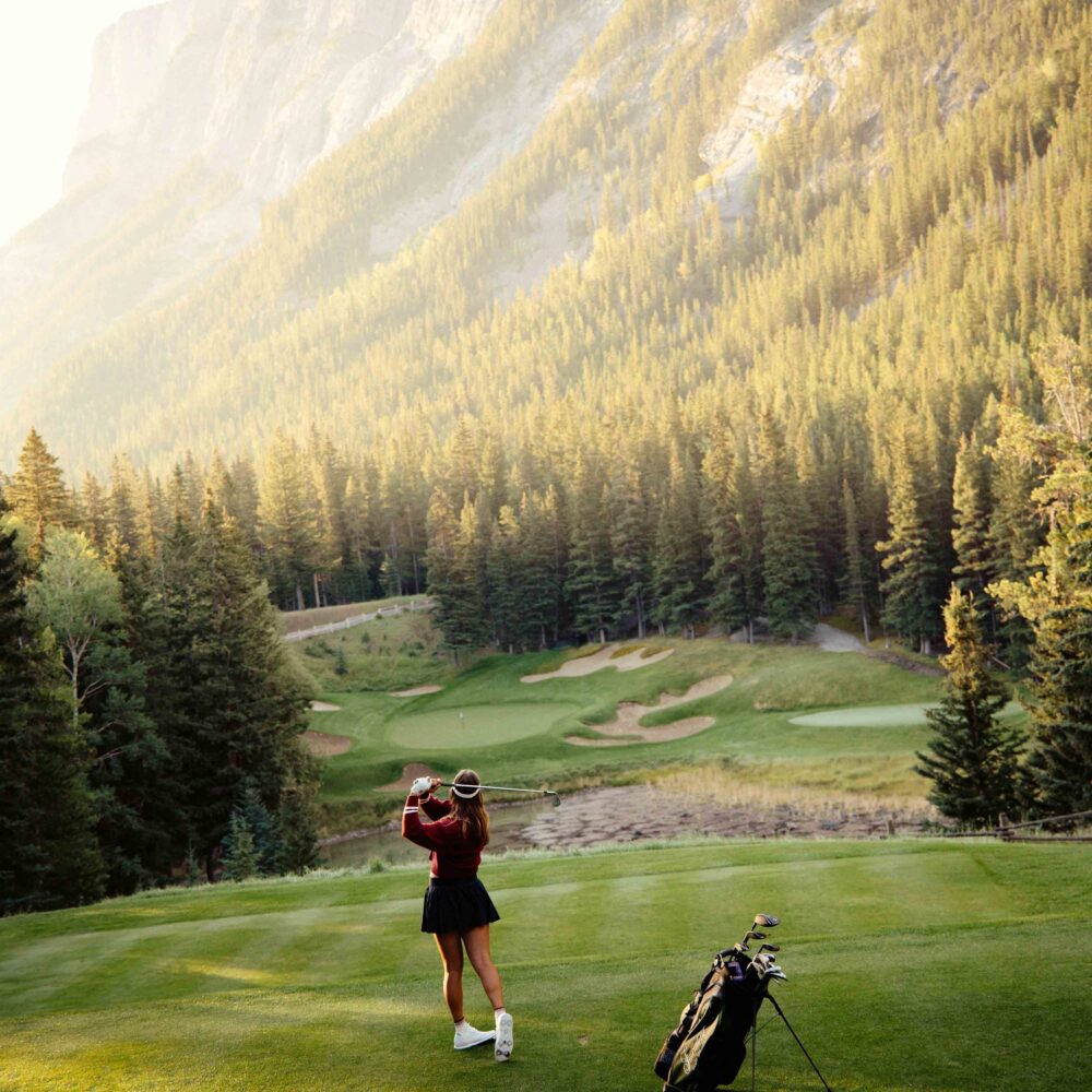 A woman hitting a drive at the Banff Springs golf course