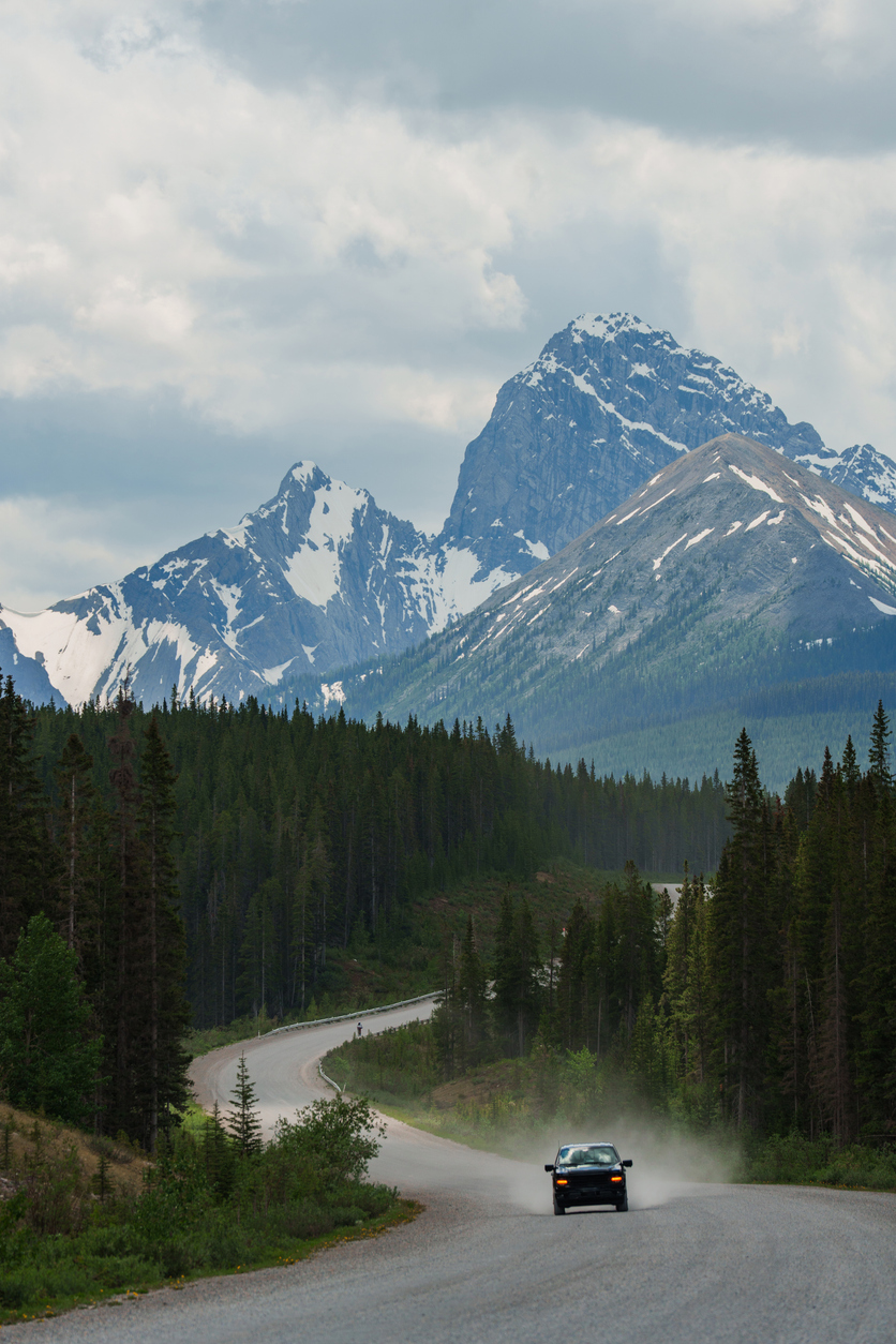 Car on the scenic road through the wilderness of Canadian Rockies in summer