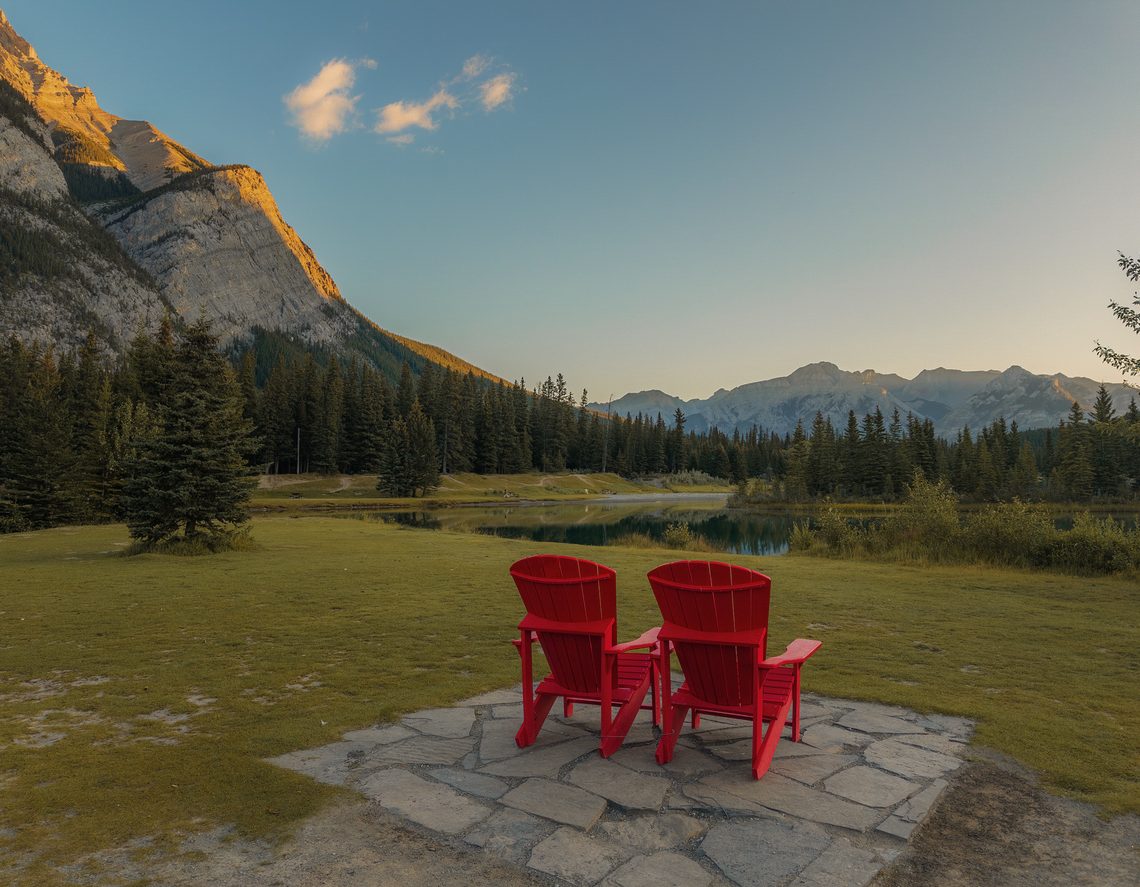 Two red parks canada chairs at Cascade Ponds in Banff overlooking the ponds
