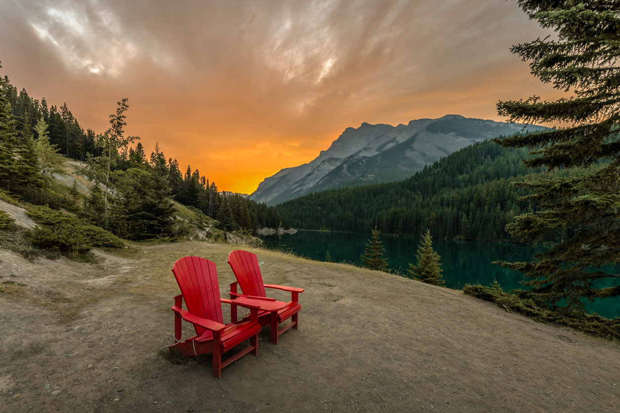 Sunrise over red chairs located at Two Jack Lake in Banff National Park