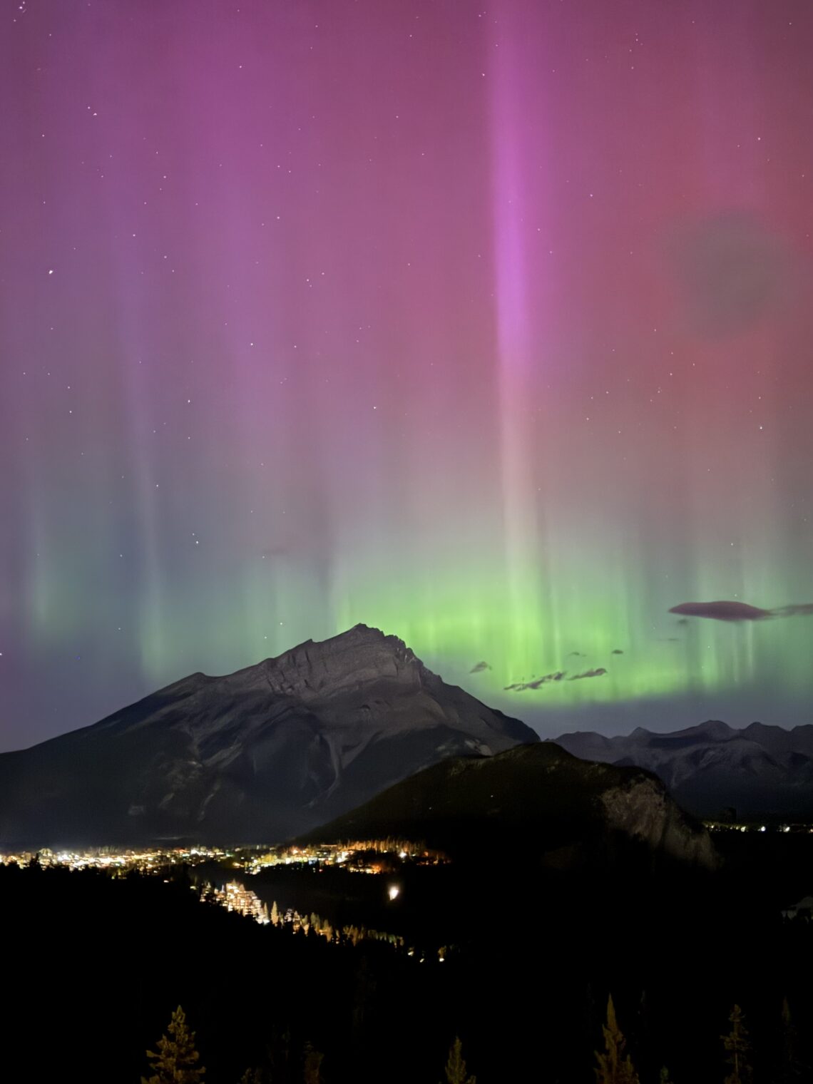The Northern Lights shining above the Town of Banff. View from the Rimrock Banff