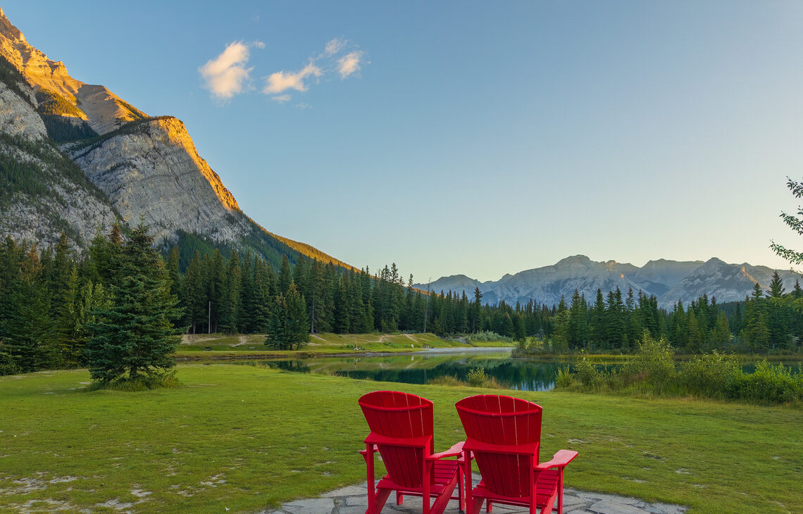 Two red parks canada chairs at Cascade Ponds in Banff overlooking the ponds