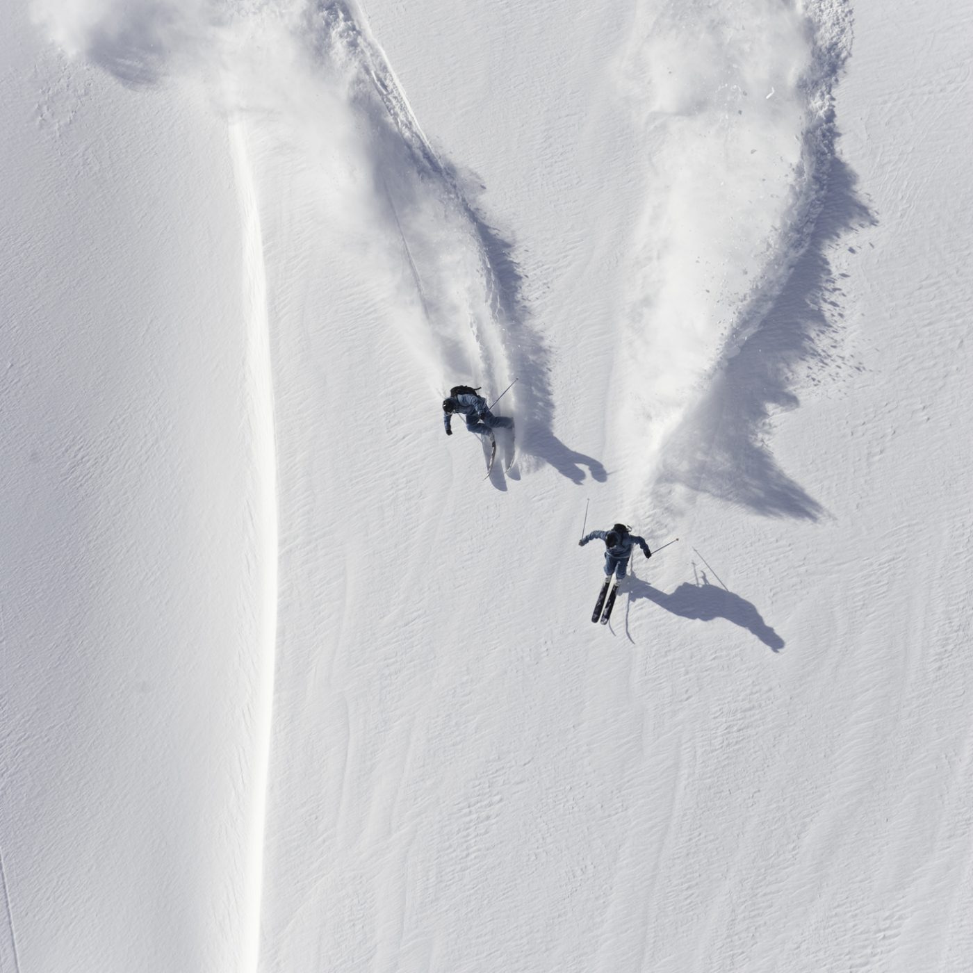Aerial view of two skiers skiing downhill in powder snow in Banff