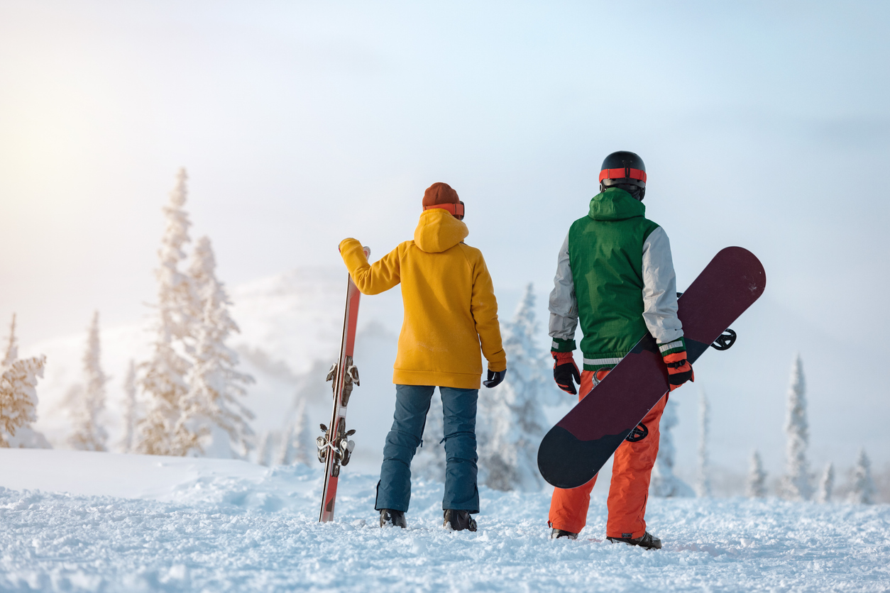 A skier and a snowboarder enjoying the hill before apres at Rimrock Banff.